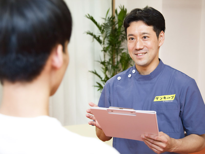 腰痛のケア方法について教える施術者